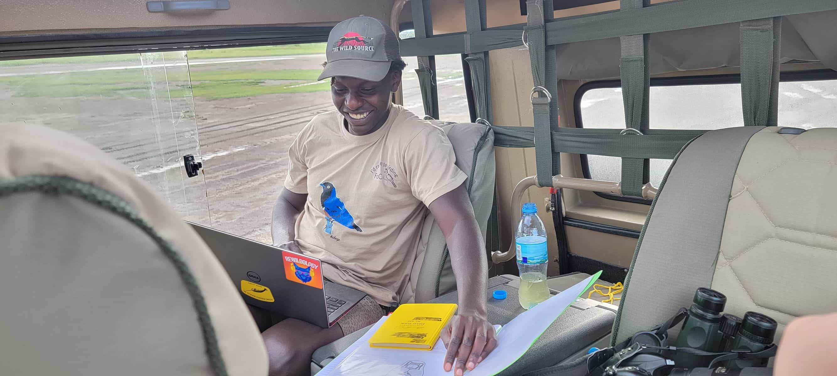 A Big Cat Project biologist recording data on a tablet from a safari vehicle