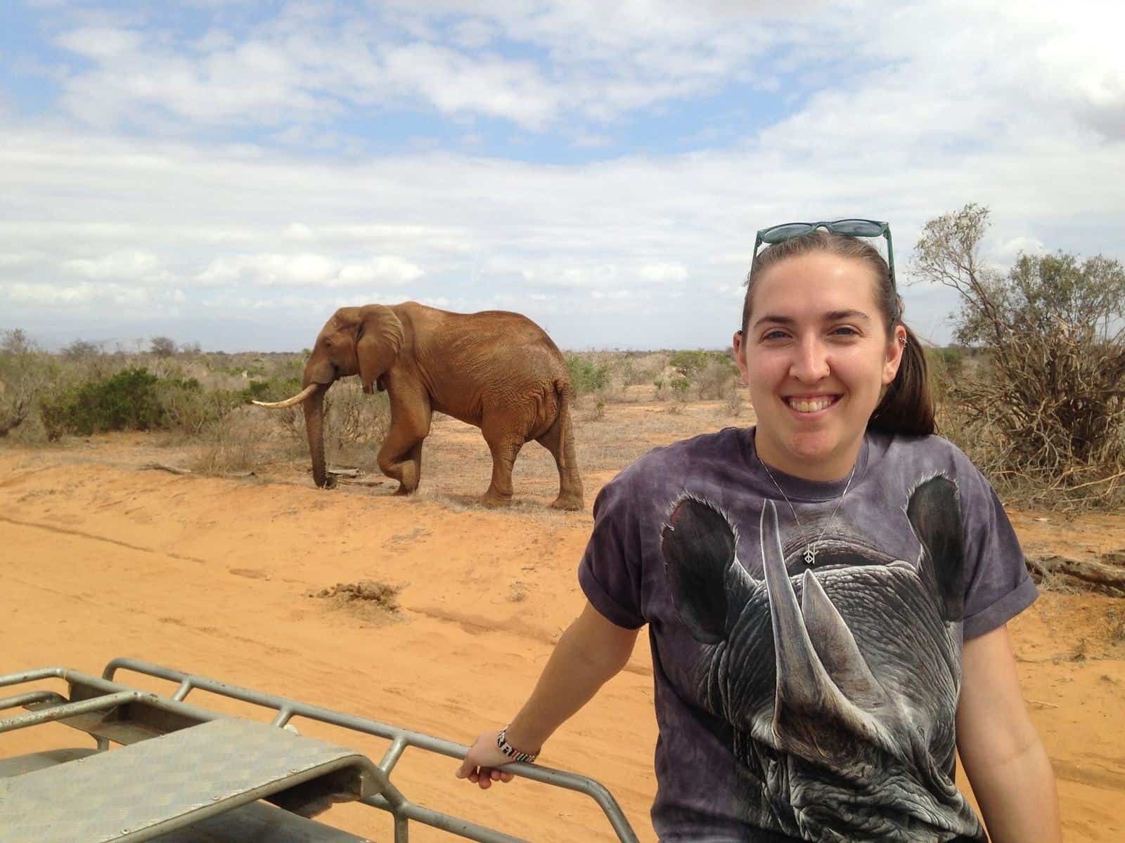 Clara Moore, wildlife biologist and Safari Specialist at The Wild Source, photographed beside an elephant