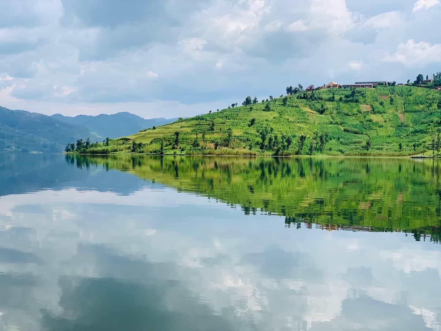 Terraced green hillside reflected in a still lake near Virunga Inn Resort & Spa, Kinigi, Rwanda